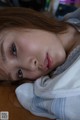 A young woman laying on top of a wooden table.