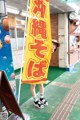 A woman standing in front of a yellow and red banner.