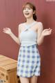 a woman in a blue and white checkered skirt posing for the camera